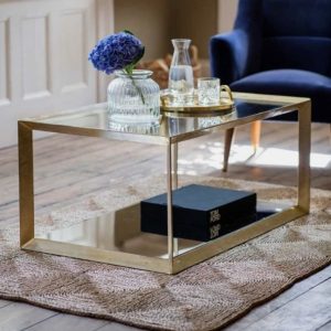 Glass coffee table with brass frame and mirrored open shelf