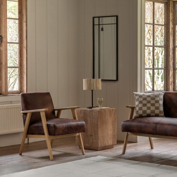 A pair of brown leather armchairs